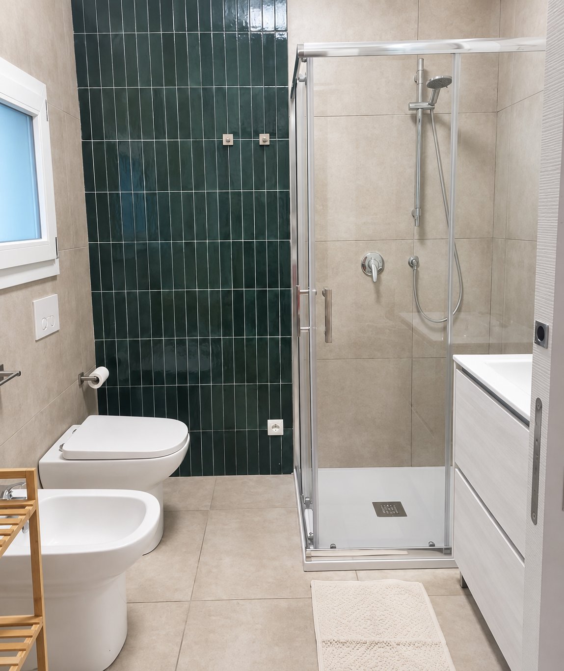 Bagno con doccia in vetro e piastrelle verdi verticali