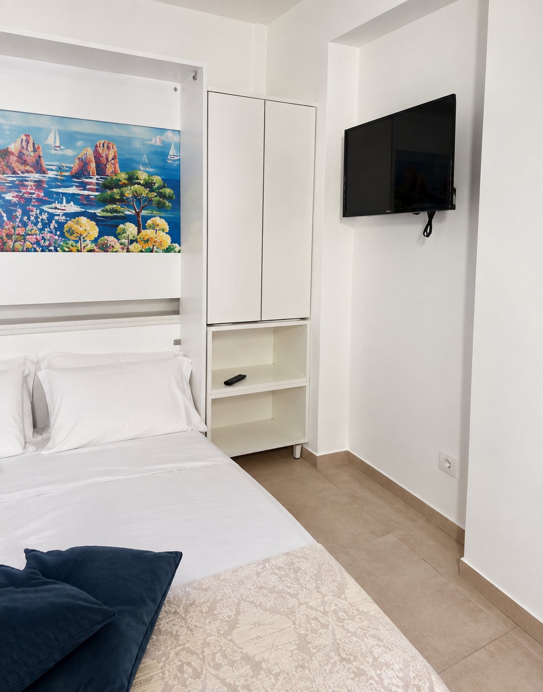 Camera da letto con armadio bianco e televisore a parete